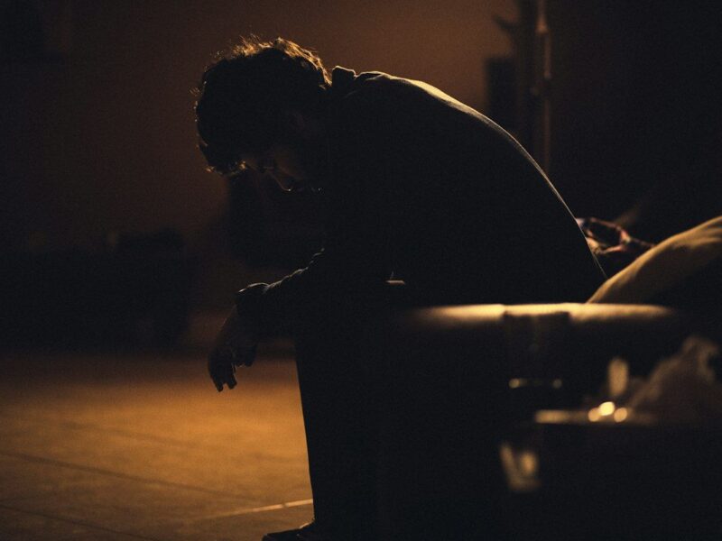 Man sitting quietly in a chair, lost in thought