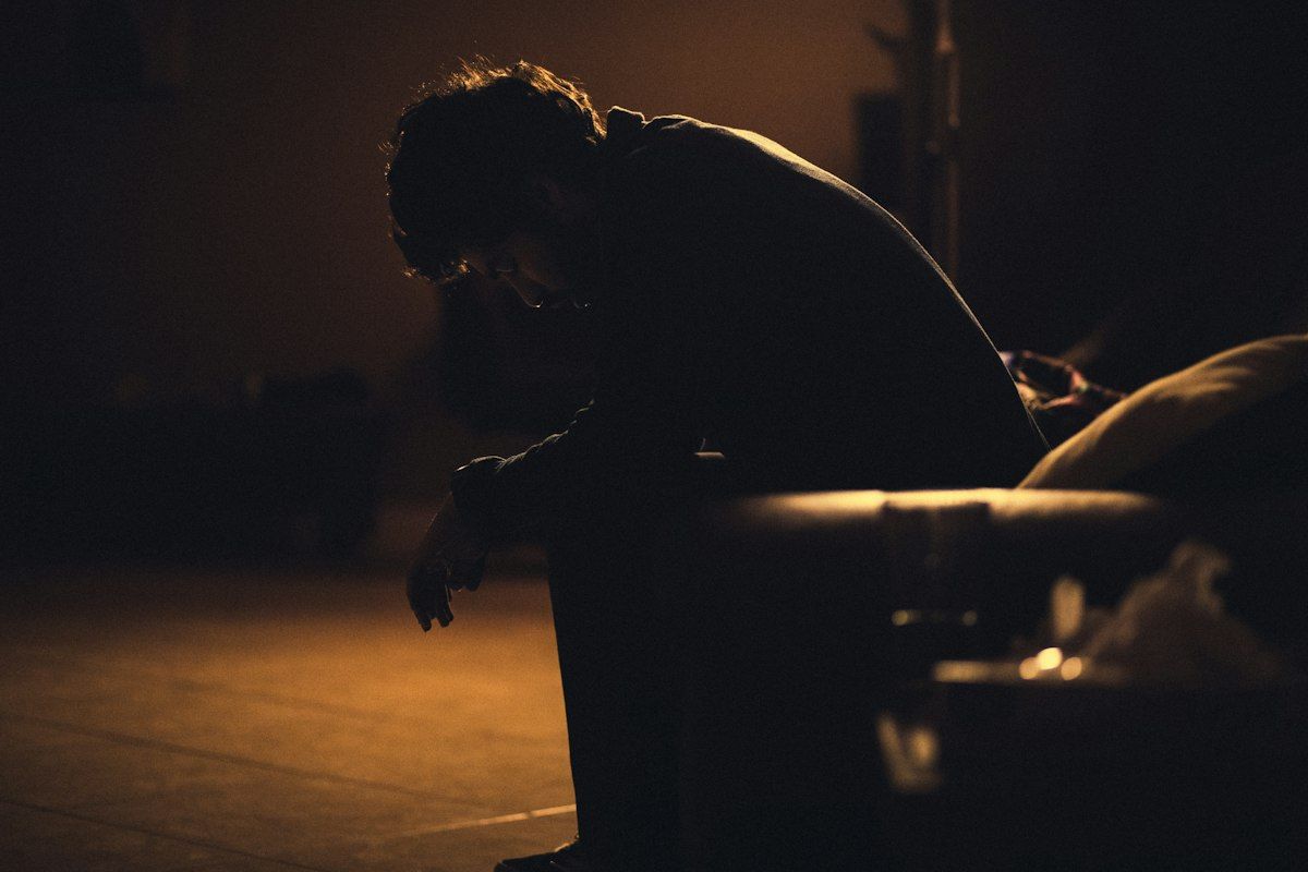 Man sitting quietly in a chair, lost in thought