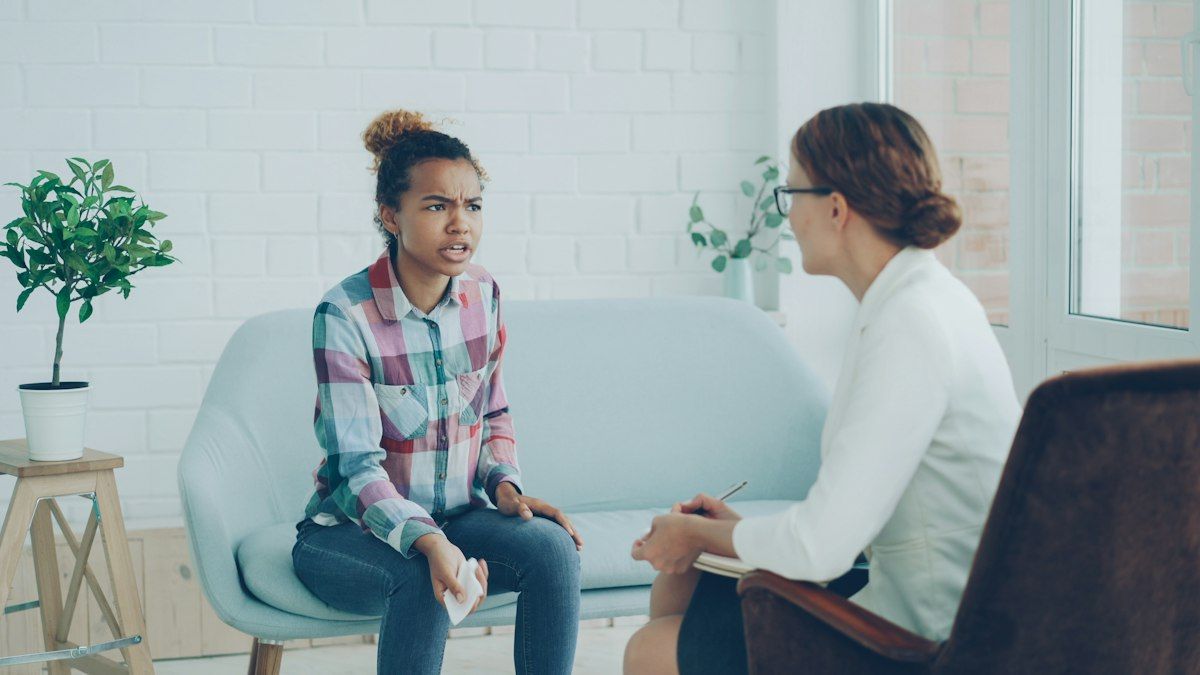 A woman talks with a therapist in a calm office