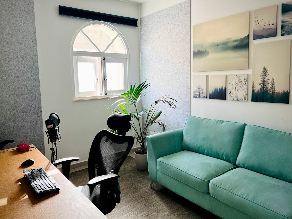 A calm consultation room with a teal sofa